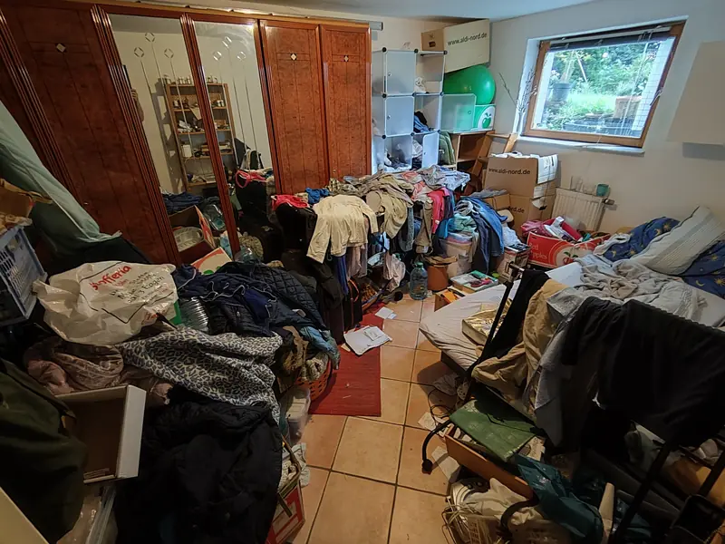 Schlafzimmer vor der Räumung: Kleiderberge, Kartons und Möbel